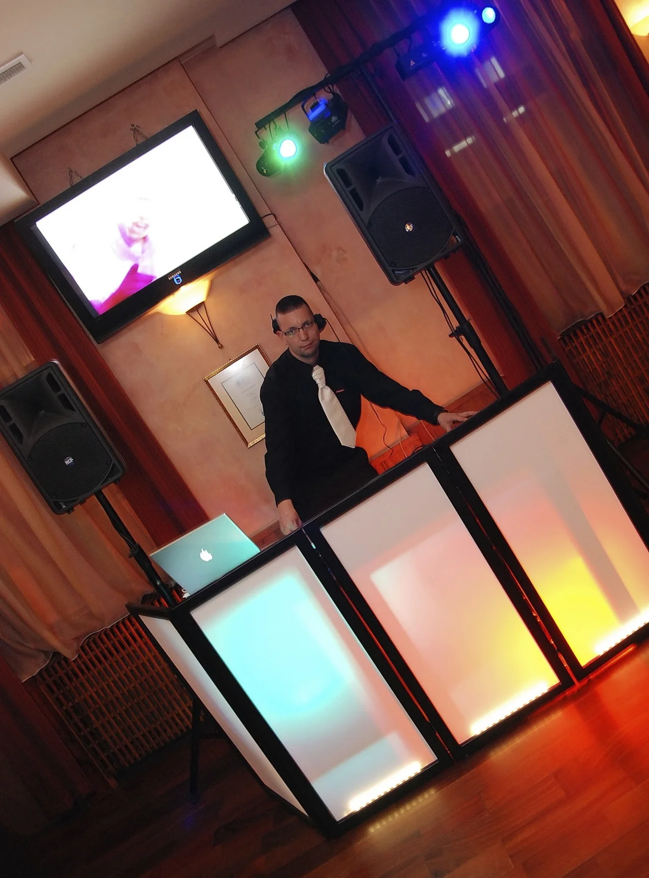 DJ Kónya Attila egyik első lakodalmas fellépésén, színes háttérvilágítással, klasszikus DJ pult mögött