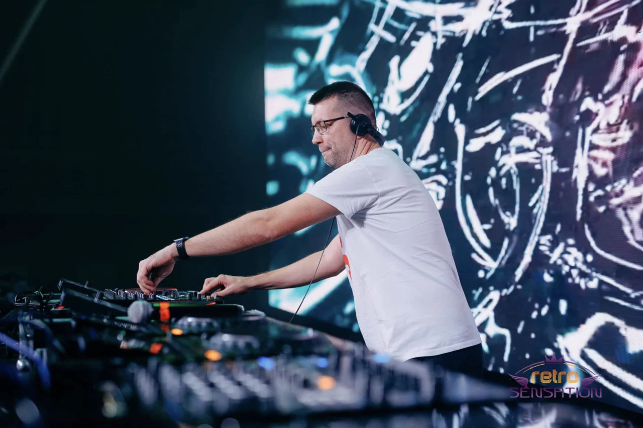 DJ munka közben, keverőpult mögött, színpadi LED fal előtt