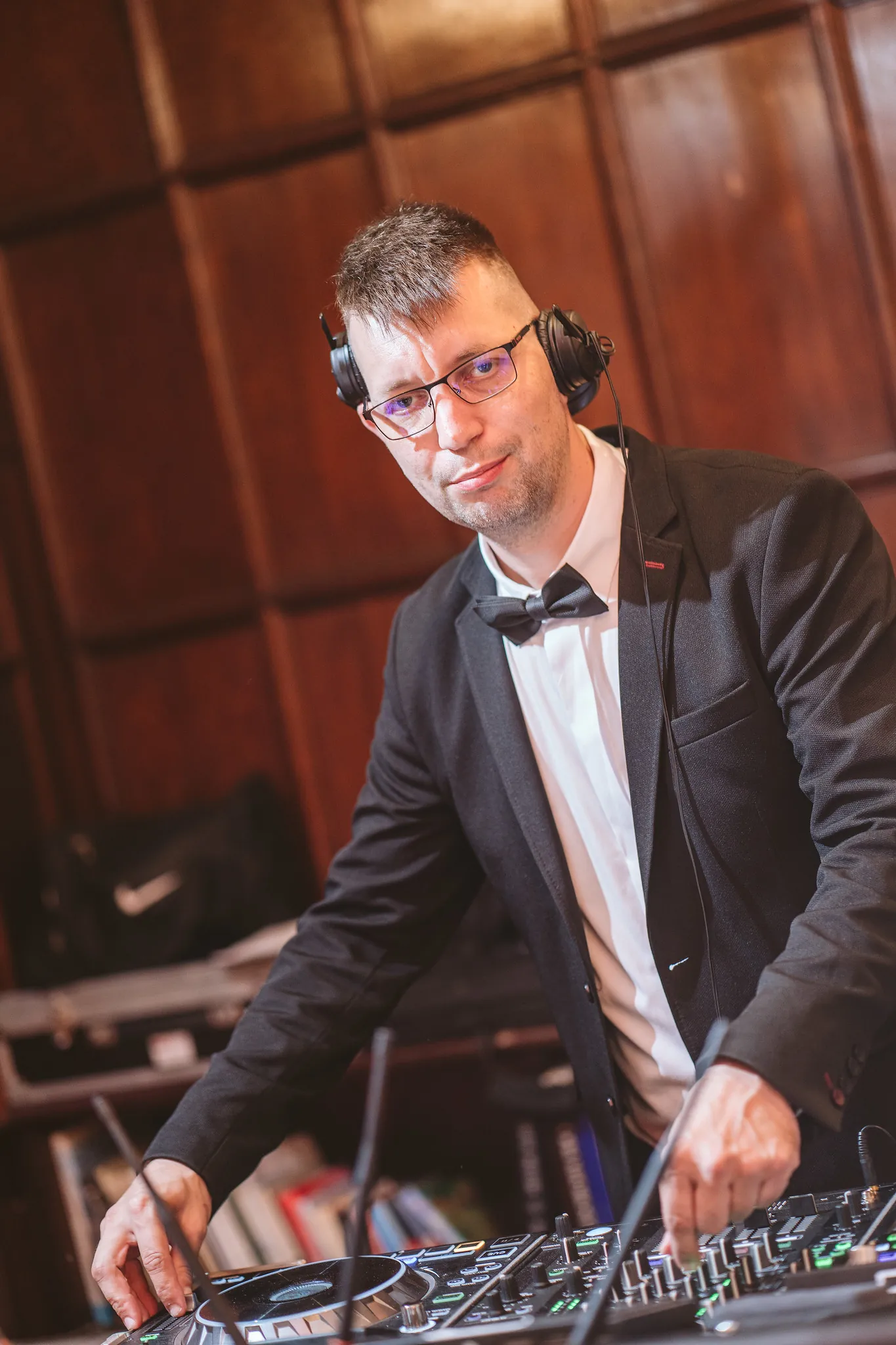 Kónya Attila, DJ pultnál elegáns öltönyben, fejhallgatóval